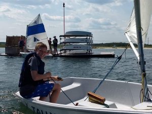 kid sailing a pram past the dock